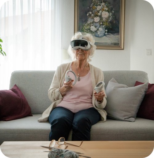 Seniorin trainiert mit VR-Brille auf dem Sofa